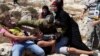 FILE - In this Aug, 28, 2015 photo, Palestinian women and girls scuffle with an Israeli soldier trying to arrest a 12-year-old boy during a protest near the West Bank village of Nebi Saleh.
