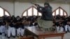 A Pakistani security official poses as a militant during a security drill Feb. 2 at the Islamia College in Peshawar.