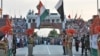 FILE- Indian and Pakistani flags are lowered during a daily retreat ceremony at the India-Pakistan joint border check post of Attari-Wagah near Amritsar, India, July 21, 2015.