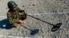 FILE - An Afghan soldier uses a mine detector during a demining drill at Camp Shaheen, a training facility for the Afghan National Army (ANA), west of Mazar-i-Sharif, Dec. 13, 2014. 
