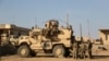 FILE - U.S. soldiers stand outside their armored vehicle on a joint base with Iraqi army south of Mosul, Iraq, Feb. 23, 2017.