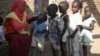 A social worker gives polio drops to children from al-Muniera village in Madani, FILE November 18, 2007. 