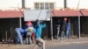 Un homme porte sur la tête un réfrigérateur qui a été pillé dans un centre commercial du township de Katlehong, à l'est de Johannesburg, le 12 juillet 2021. (photo d'archives). 