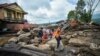 Warga berjalan di kawasan terdampak hujan lebat yang membawa banjir bandang dan tanah longsor saat mereka mengungsi di Agam, provinsi Sumatera Barat, 12 Mei 2024. (Antara Foto/Iggo El Fitra/via REUTERS)
