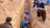FILE - Men excavate remains of more than 25 men reportedly killed by Islamic State fighters on the outskirts of Saadia in Iraq's Diyala province, Jan. 15, 2015. 