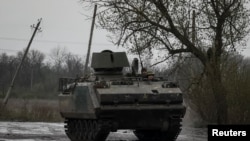 Ukrainian servicemen ride inside a M113 armoured personnel carried on a road to the front line town of Bakhmut in Donetsk region