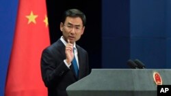 FILE - Chinese Foreign Ministry spokesman Geng Shuang gestures as he speaks during a daily briefing at the ministry in Beijing, Sept. 4, 2017.