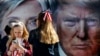 FILE - Girls pause near a bus displaying large photos of candidates Hillary Clinton and Donald Trump before the presidential debate at Hofstra University in Hempstead, New York, Sept. 26, 2016.