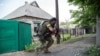 Ukrainian serviceman holds a gun during fighting in Mariinka, in the region of Donetsk, June 4, 2015.