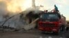 A Civil Defense member and a man put out a fire after an airstrike on the rebel held Urm al-Kubra town, western Aleppo city, Syria, Sept. 20, 2016.