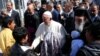 Le pape François, au centre, salue les enfants réfugiés à son arrivée au camp de ces derniers à Moria, sur l’ île de Lesbos, Grèce, 16 avril 2016. epa/ ORESTIS 