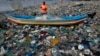 FILE - A fisherman prepares his net on the shores of the Arabian Sea, littered with plastic bags, in Mumbai, India, Oct. 1, 2015. At the Our Ocean summit that concluded Friday, five countries detailed plastic bag bans.