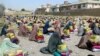 FILE - Afghan burqa-clad women sit after they received ration aid in Kandahar, Afghanistan, May 4, 2016. 