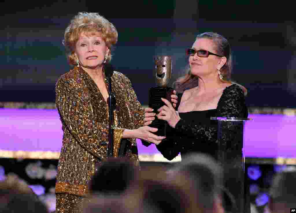 អ្នកស្រី Carrie Fisher ប្រគល់ពានរង្វាន់ ស្នាដៃពេញមួយជីវិត SAG ទៅឲ្យអ្នកស្រី Debbie Reynolds ក្នុងកម្មវិធីប្រគល់ពានរង្វាន់ Screen Actors Guild ទី២១ ប្រចាំឆ្នាំនៅសាល Shrine Auditorium កាលពីថ្ងៃទី ២៥ មករា ២០១៥ ទីក្រុង Los Angeles។