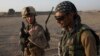 FILE - U.S. Marine 1st Lt. Zachary Bennett talks with an Afghan interpreter during a joint patrol in Helmand province, southern Afghanistan, Sept. 19, 2009.