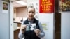 Karen Short, wife of Australian missionary John Short, poses with a photo of her husband inside the Christian Book Room in Hong Kong, Feb. 20, 2014. 