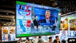 香港一家餐厅悬挂着显示美国大选初步结果的电视萤幕。(2024年11月6日)
