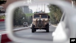 A patrolling U.S. armored vehicle is reflected in the mirror of a car in Kabul, Afghanistan, Aug. 23, 2017. 