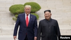 도널드 트럼프 미국 대통령과 김정은 북한 국무위원장이 지난 6월 30일 판문점 회동에서 군사분계선을 함께 넘고 있다. 