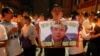 Friends and supporters wearing t-shirts with the image of lawyer Le Quoc Quan hold hands while attending a mass calling for Quan to be freed at Thai Ha church in Hanoi September 29, 2013. 