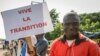Un partisan tient une pancarte en français lisant «Vive la transition», à l'extérieur où une cérémonie de prestation de serment du président et du vice-président de transition a eu lieu, dans la capitale Bamako, Mali, vendredi 25 septembre 2020. 