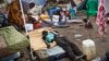 FILE - A sick displaced man lies asleep on a bed while a mother bathes her son and keeps an eye on her other child in the United Nations camp in Juba, South Sudan, Feb. 12, 2014. 
