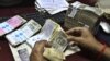 An employee counts Indian rupee notes at a bank in Allahabad, India, May 16, 2012.
