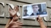 A supporter holds a picture of Edward Snowden, a former CIA employee who leaked top secret information about U.S. surveillance programs, outside the U.S. Consulate General in Hong Kong, June 13, 2013. 