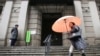A woman walks past in front of Bank of Japan, Jan. 29, 2016. The Bank of Japan on Friday introduced a negative interest policy for the first time, seeking to shore up a stumbling recovery in the world's third-largest economy. 