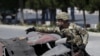FILE - A U.S. soldier inspects the site of a suicide bomb attack in Kabul, Afghanistan, June 30, 2015.