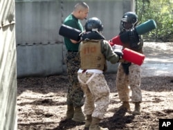 FILE - Female recruits battle with pugil sticks during training at the Marine Corps Training Depot on Parris Island, S.C., Feb. 21, 2013.
