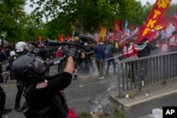 Seorang polisi Turki menggunakan senapan anti huru hara untuk membubarkan anggota Serikat saat mereka berbaris saat perayaan Hari Buruh di Istanbul, Turki, Rabu, 1 Mei 2024. (Foto: AP)