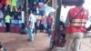 Un groupe de vendeurs au marché central à Yaoundé discutent sur la question de la longévité au pouvoir des présidents africains, Cameroun, le 22 novembre 2017. (VOA/Emmanuel Jules Ntap)