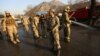 Afghan security forces inspect the site of a suicide attack at the gate of a Civil Order Police compound, in Kabul, Afghanistan, Feb. 1, 2016.