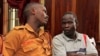 Thomas Kwoyelo (à droite), membre présumé de la LRA (Armée de résistance du Seigneur), lors d'une audience préliminaire à la Haute Cour de Kampala le 1er février 2017.