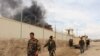 FILE - Smoke rises from a building, where Taliban insurgents hide during a firefight with Afghan security forces, in Helmand province, southwest Afghanistan, March 9, 2016.