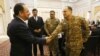 Afghan Foreign Minister Salahuddin Rabbani, left, shakes hands with a Pakistani officer during a meeting to discuss a road map for ending the war with the Taliban, at the Presidential Palace in Kabul, Afghanistan, Feb. 23, 2016.