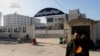 A Syrian rebel stands at the entrance to the headquarters of the Islamic State of Iraq and the Levant, after it fall to the Syrian rebels, in Aleppo, Syria, Wednesday Jan. 8, 2014. (AP Photo/Aleppo Media Center, AMC)