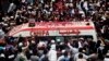 People throw rose petals on an ambulance carrying the body of Pakistani Sufi singer Amjad Sabri during his funeral in Karachi, Pakistan, June 23, 2016.