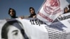 Human rights activists hold a banner with a portrait of Erdal Eren, a leftist executed during the military rule after the coup in 1980, as they demonstrate in front of a courthouse in Ankara, April 4, 2012.