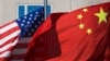 U.S. flag and China's flag flutter in winds at a hotel in Beijing.