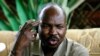 FILE - Ahmed Harun, then-governor of South Kordofan, a Sudanese province, gestures during a press conference in Talodi, South Kordofan, April 12, 2012. 