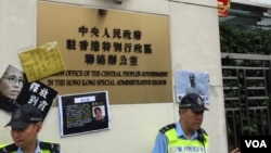 香港社民連和支聯會把抗議標語貼在中聯辦門前。（美國之音海彥拍攝）