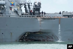 FILE - damage is visible as the guided-missile destroyer USS John S. McCain steers towards Changi naval base in Singapore following a collision with the merchant vessel Alnic MC.