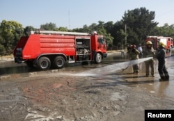 Afghan fire-fighters clean the site of a suicide attack in Kabul, Afghanistan, June 20, 2016.