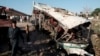 Afghans and security forces inspect damage to a bus after a suicide attack in Jalalabad east of Kabul, April 11, 2016.