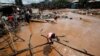 Seorang gadis melangkah melalui banjir udara setelah Sungai Nairobi meluap dan menghancurkan rumah mereka di pemukiman lembah Mathare di Nairobi, Kenya, 24 April 2024. (Foto: REUTERS/Monicah Mwangi)