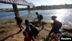 Para migran berjalan di sepanjang tepi sungai Rio Grande sebelum menyeberang dalam upaya mencari suaka ke AS, terlihat dari Piedras Negras, Meksiko, 29 September 2023. (Foto: REUTERS/Daniel Becerri)