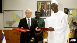  L'ex ministre malien de la Défense Bah N'Daw, à droite, et son homologue français Jean-Yves Le Drian se rencontrent à Bamako, le 16 juillet 2014. Bah N'Daw a été nommé président du Mali pour la période de transition.