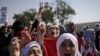 Syrians, who fled their homes due to fighting between the Syrian army and the rebels, shout slogans as they march toward the Turkish side of the border, August 28, 2012 